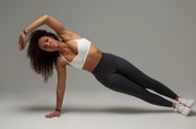 Model im aniri SculptAir Sport-BH in Ivory und SculptAir Leggings in Grau – Side-Plank Position