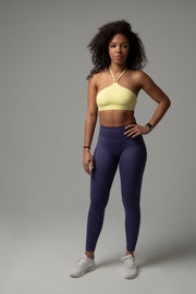 Frontansicht Model im aniri SculptAir One-Shoulder Bra in Gelb mit High-Waist Leggings