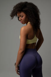 Seitliche Rückansicht aniri SculptAir One-Shoulder Bra in Creme mit High-Waist Leggings