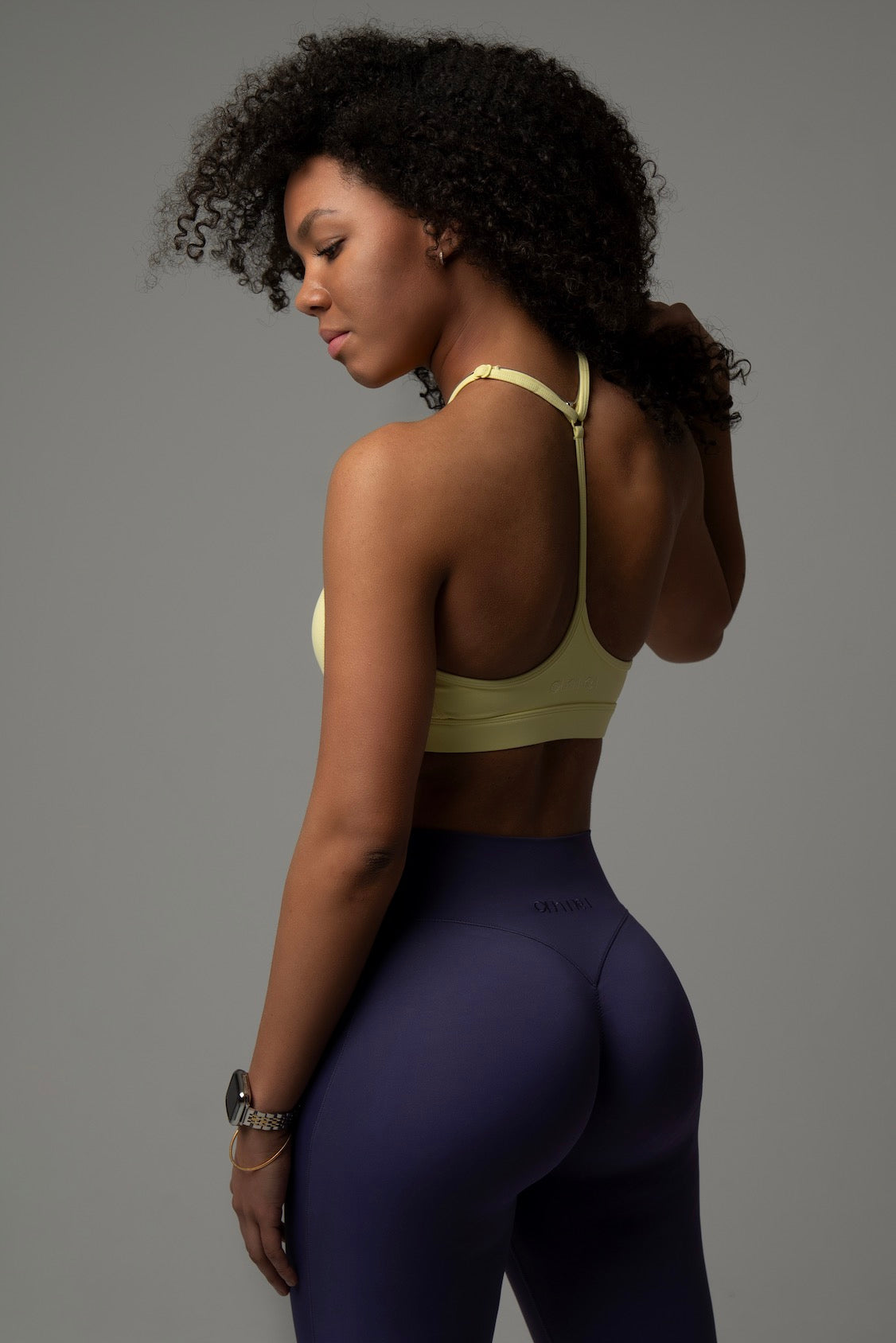 Rückenansicht Model im aniri SculptAir One-Shoulder Bra in Gelb