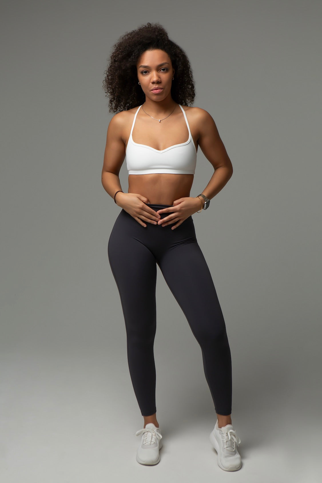 Model trägt aniri SculptAir Pure Bra in Weiß mit schwarzen High-Waist Leggings – Frontansicht